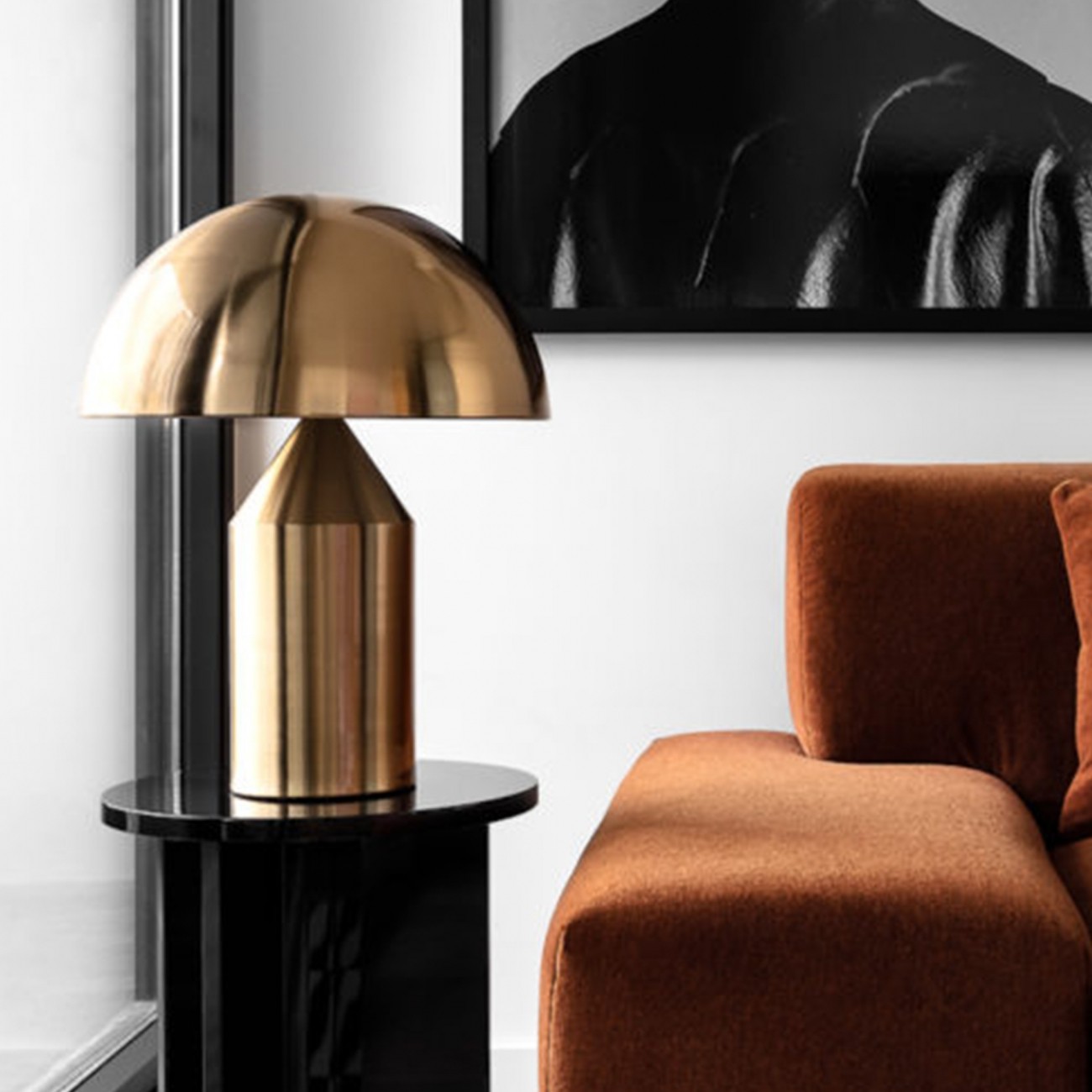 Oluce Atollo table lamp in dark bronze on a marble-topped cabinet against a plastered wall