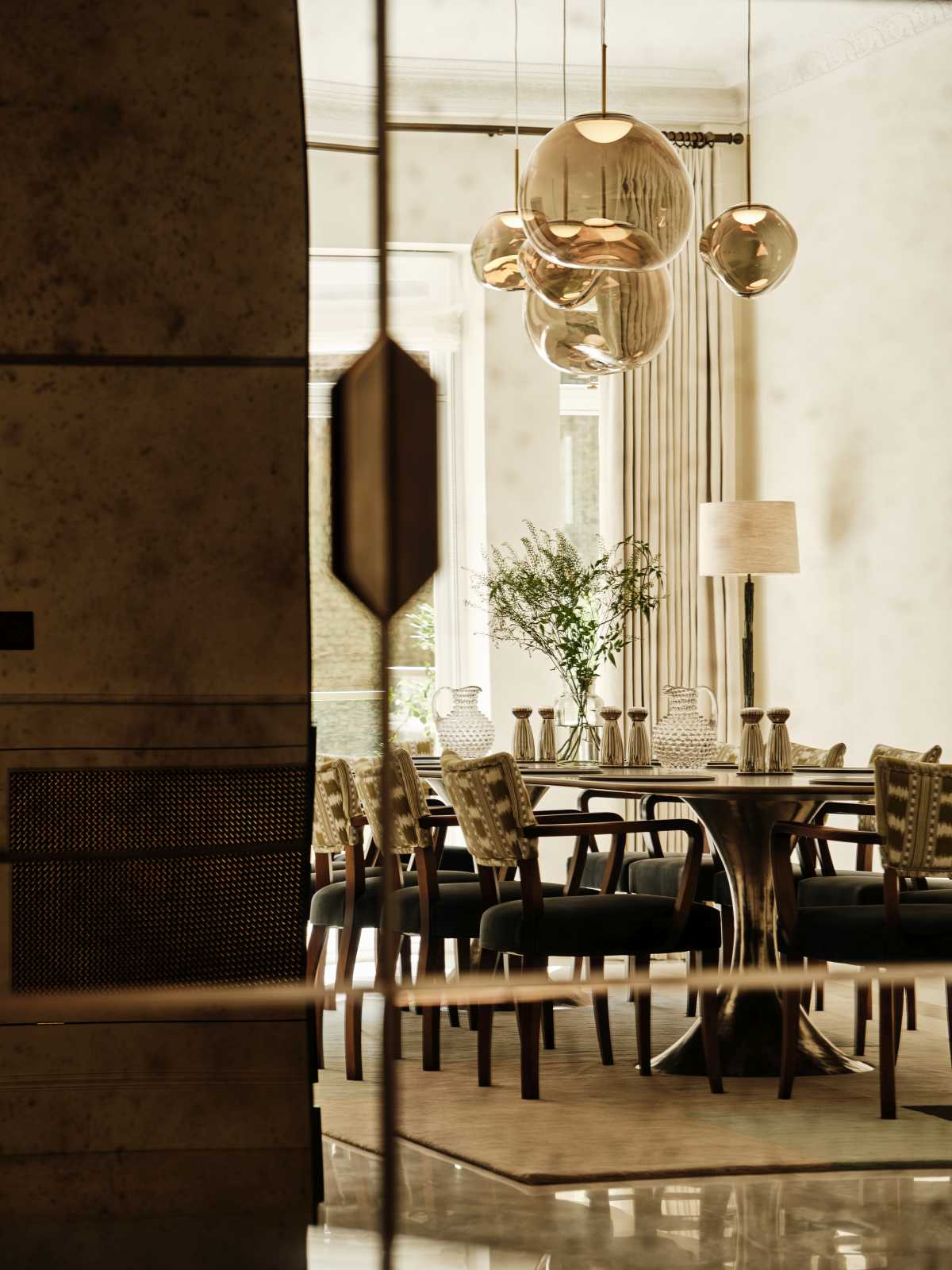 A unique dining room framed by custom black steel-framed glass doors, showcasing the tailored craftsmanship of bespoke London architectural firms.