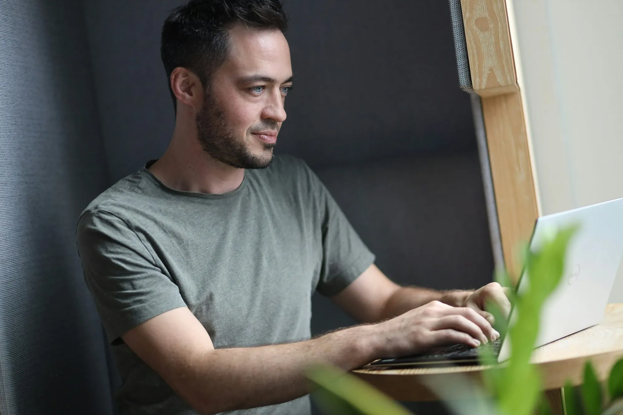 A support lead working on a laptop in a quiet office booth