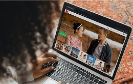 A decorative image featuring a woman sitting with a laptop, browsing the home page of New Faith Network.