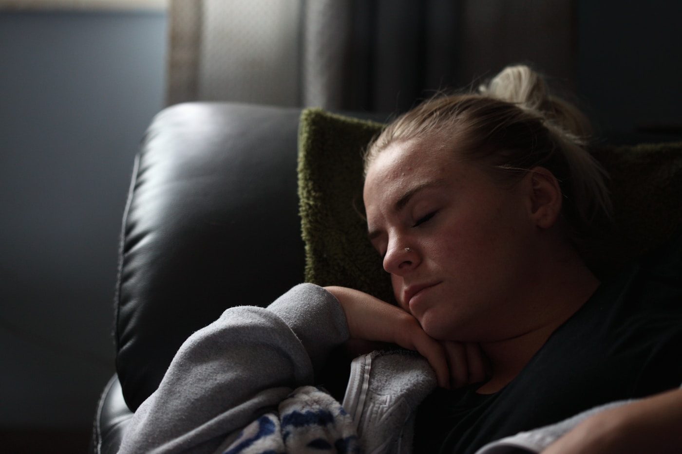 A tired woman resting on a couch, reflecting the persistent fatigue that is common with Hashimoto's disease