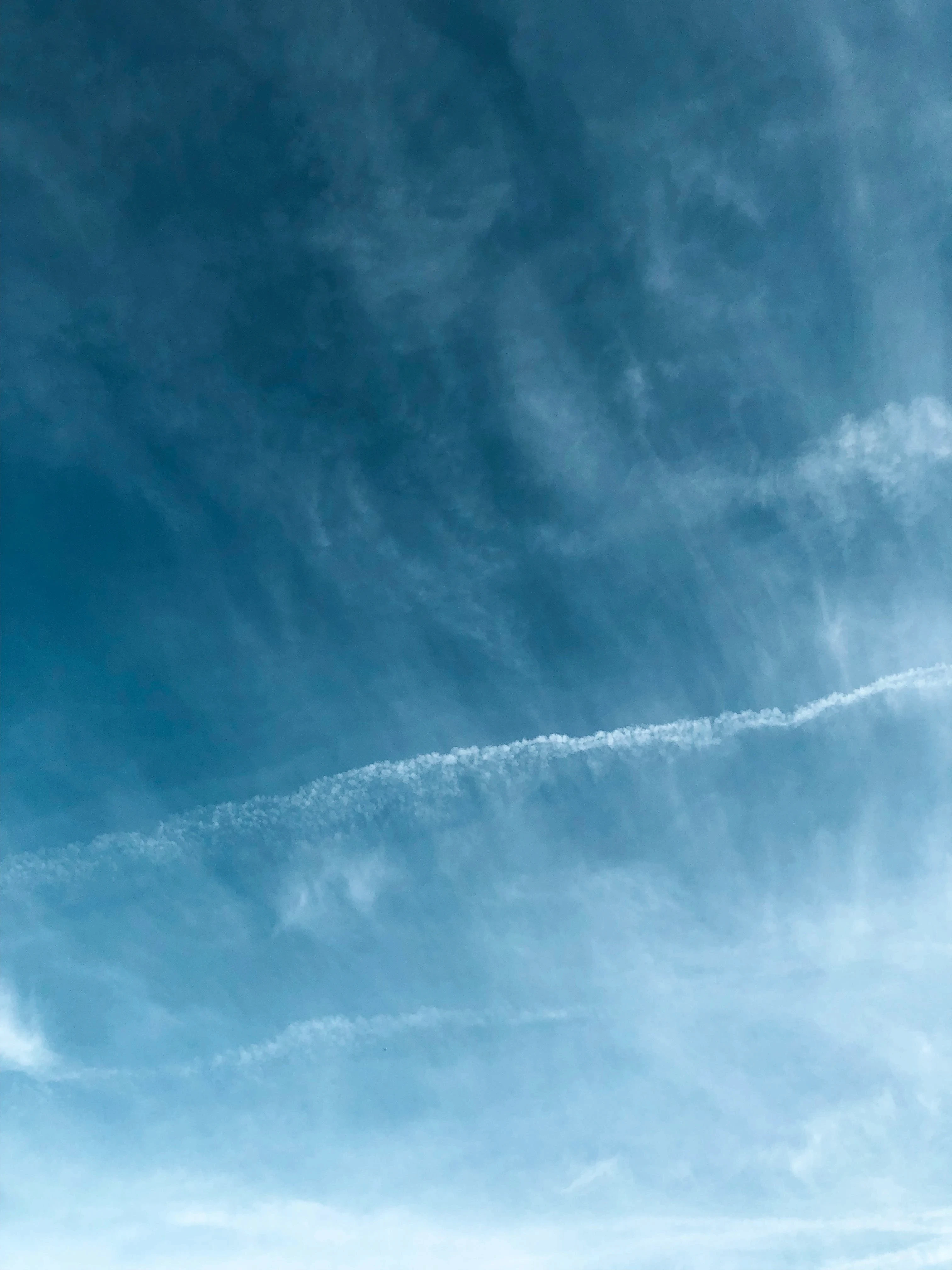 Abstract pattern of wispy white clouds against a blue sky