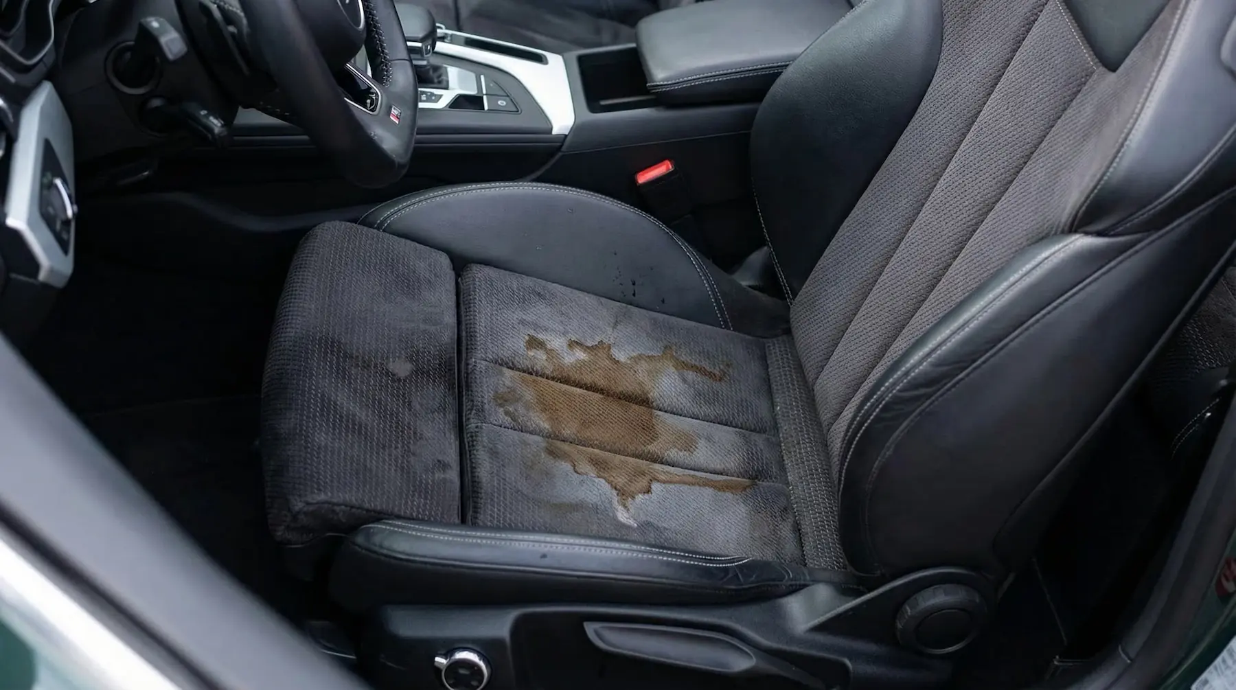 Tache de café sur le siège avant d’une voiture en tissu