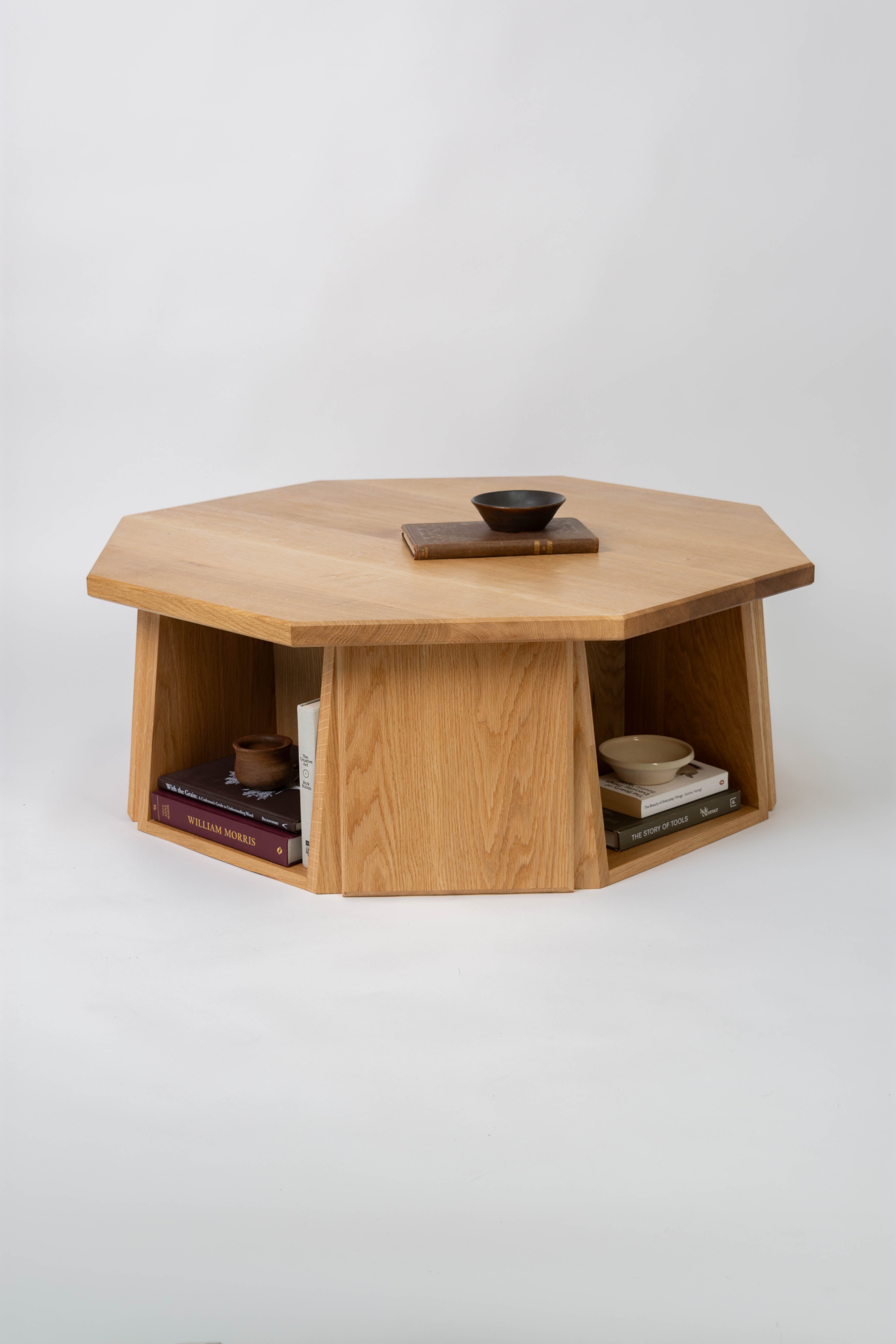 Octagonal wooden table with decorative items on a white background