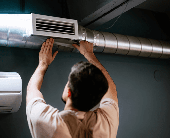 Technician inspecting and adjusting residential ductwork system in Toronto for improved airflow and indoor air quality.