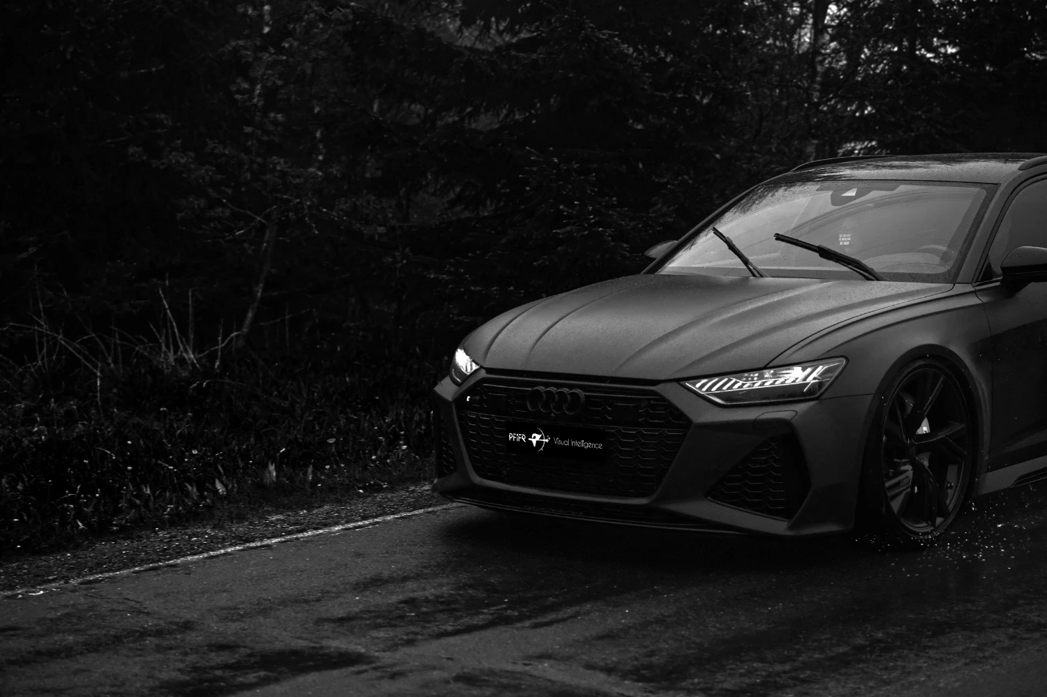 Schwarz-weißer Audi RS6 in dynamischer Frontansicht auf nasser Waldstraße, fotografiert in cinematischem Low-Light-Stil als Projekt von PFiFR® Visual Intelligence.