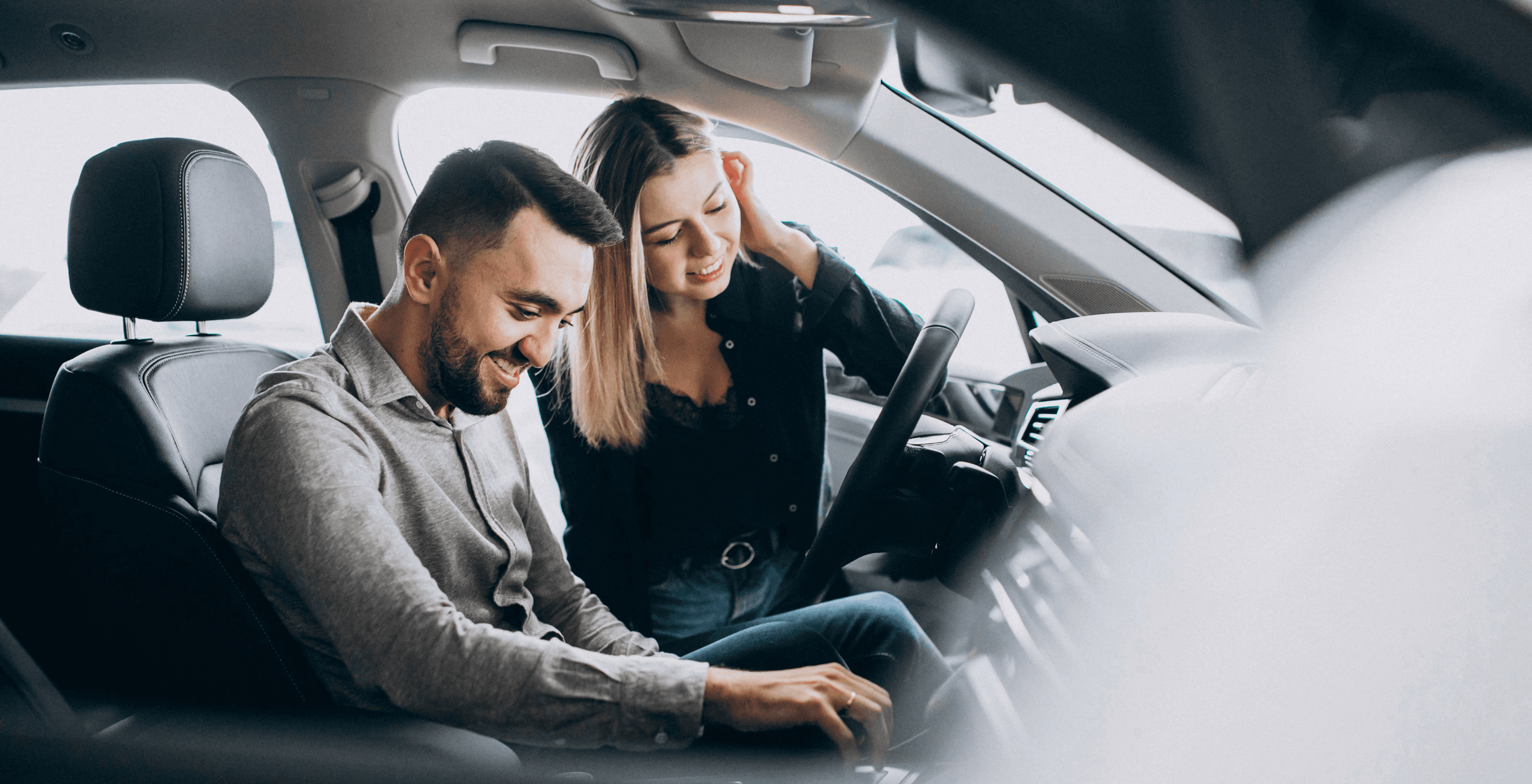 Two cheerful men laughing in the front seats of a sportscar, great for car rental joy promotions.