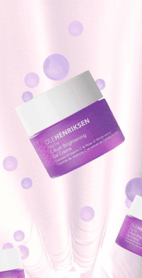 An Ole Henriksen product jar floats at an angle amidst purple bubbles and cloth.