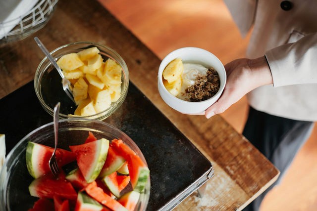 Ferskur ananas og vatnsmelóna á morgunverðarhlaðborðinu, ásamt skál af granóla og ávöxtum