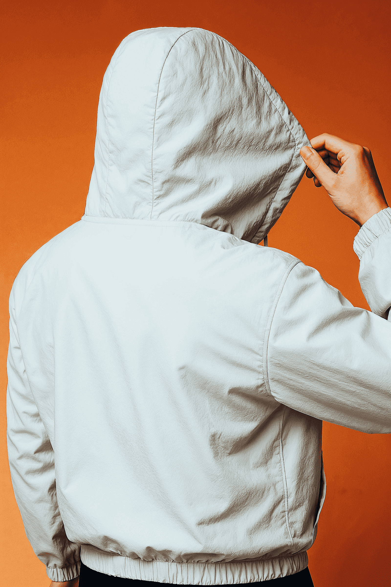 Man in motion walking forward wearing a white coat against an orange background