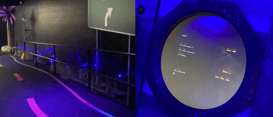 A photo of a museum exhibit where glowing grass and a screen inside a cirlce portal is visible
