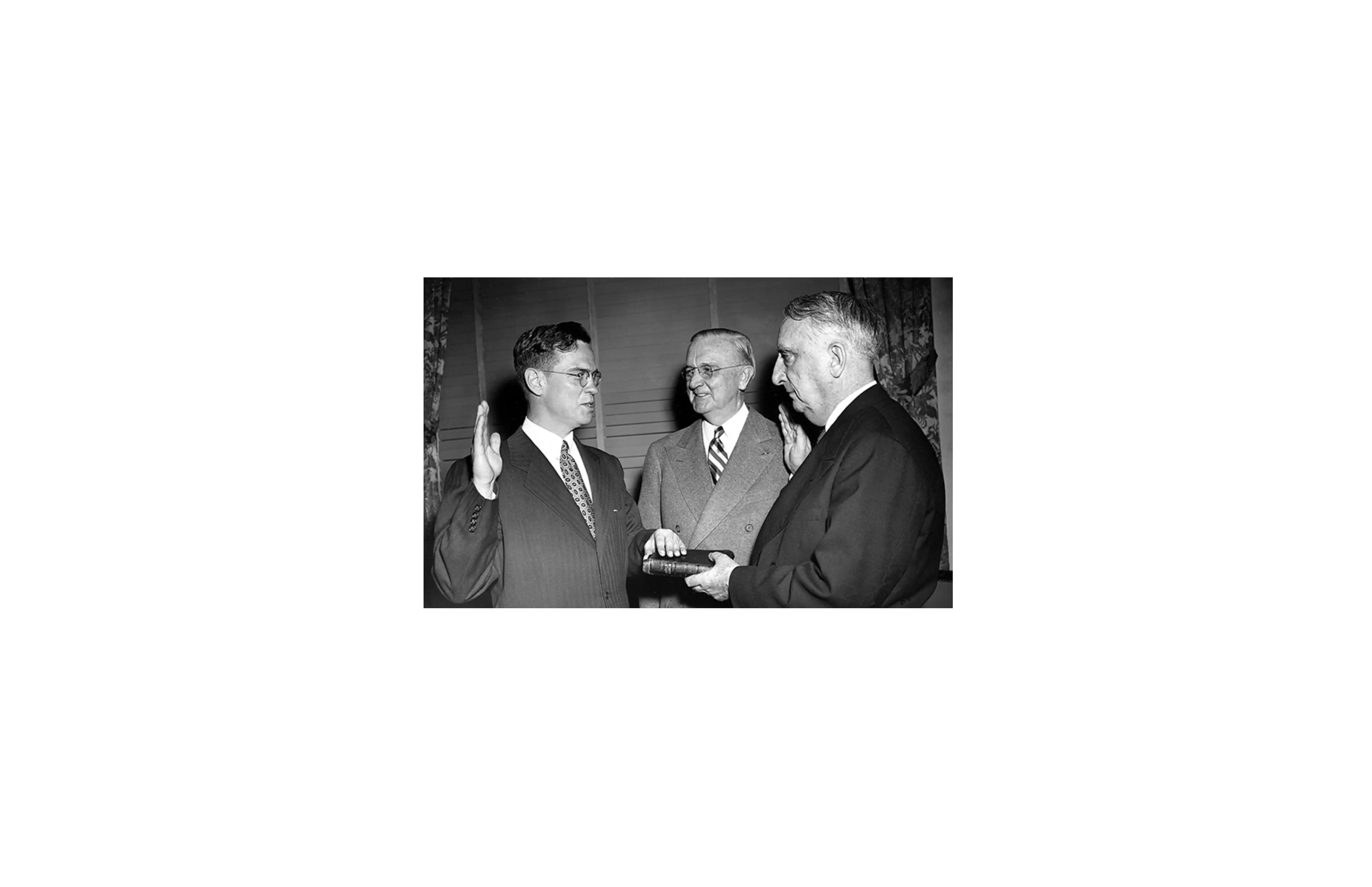 Black-and-white photograph of William McChesney Martin Jr. taking the oath as Federal Reserve Chair in 1951, with President Harry Truman watching.