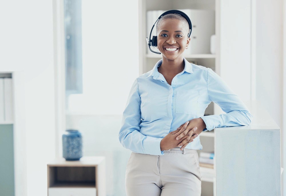 Business woman with a headset smiling, showing guaranteed uptime and reliability.