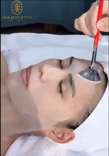 Applying Korean Glow facial chemical peel with brush.