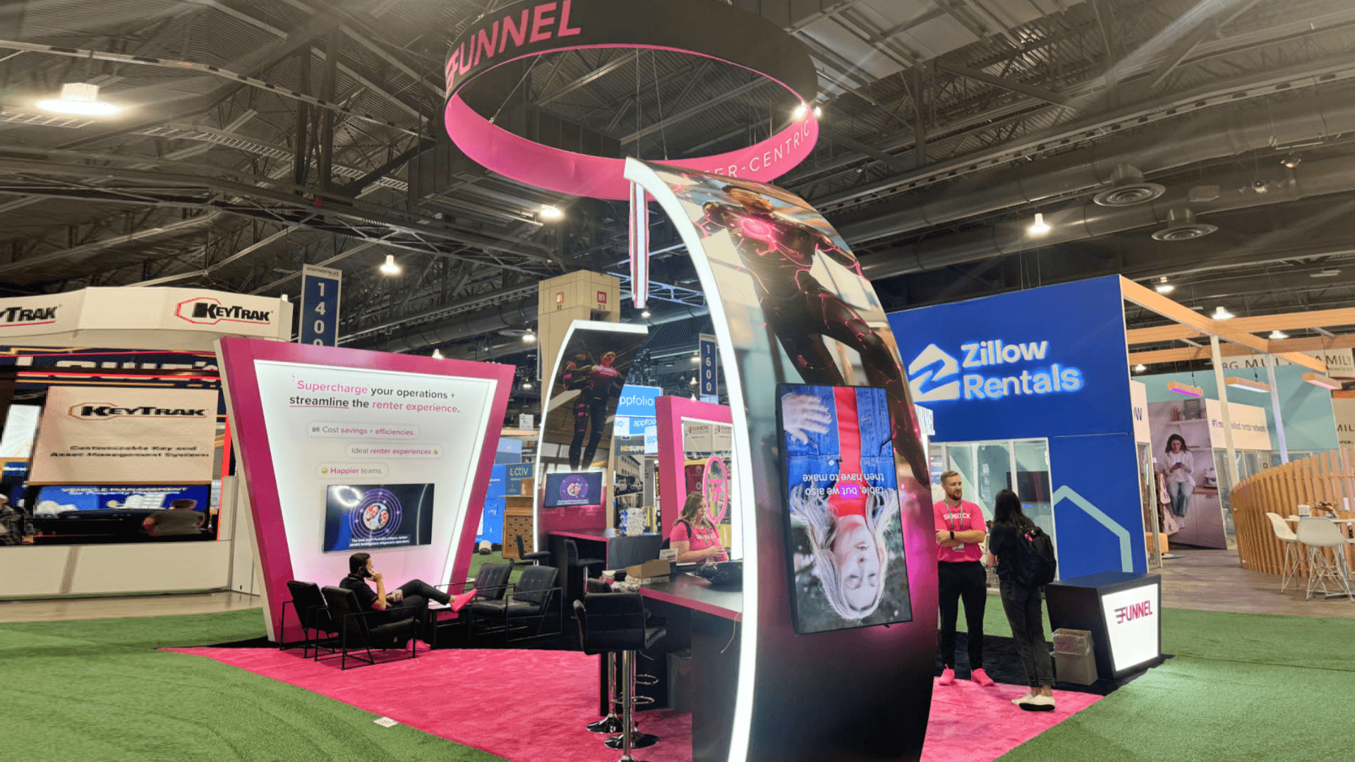 Chicago exhibit installation at McCormick Place with suspended circular hanging sign, integrated LED display wall, and structured meeting space