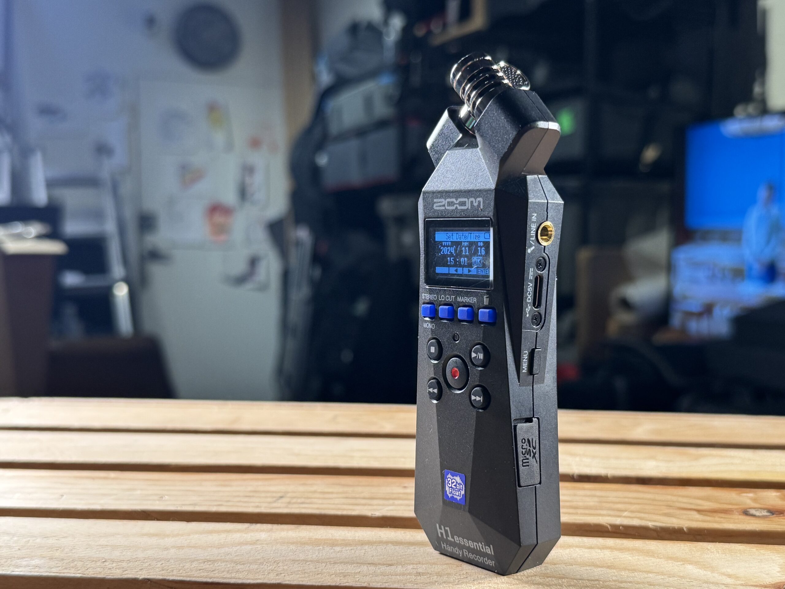 A side profile view of a black Zoom portable audio recorder, showcasing its side buttons and ports