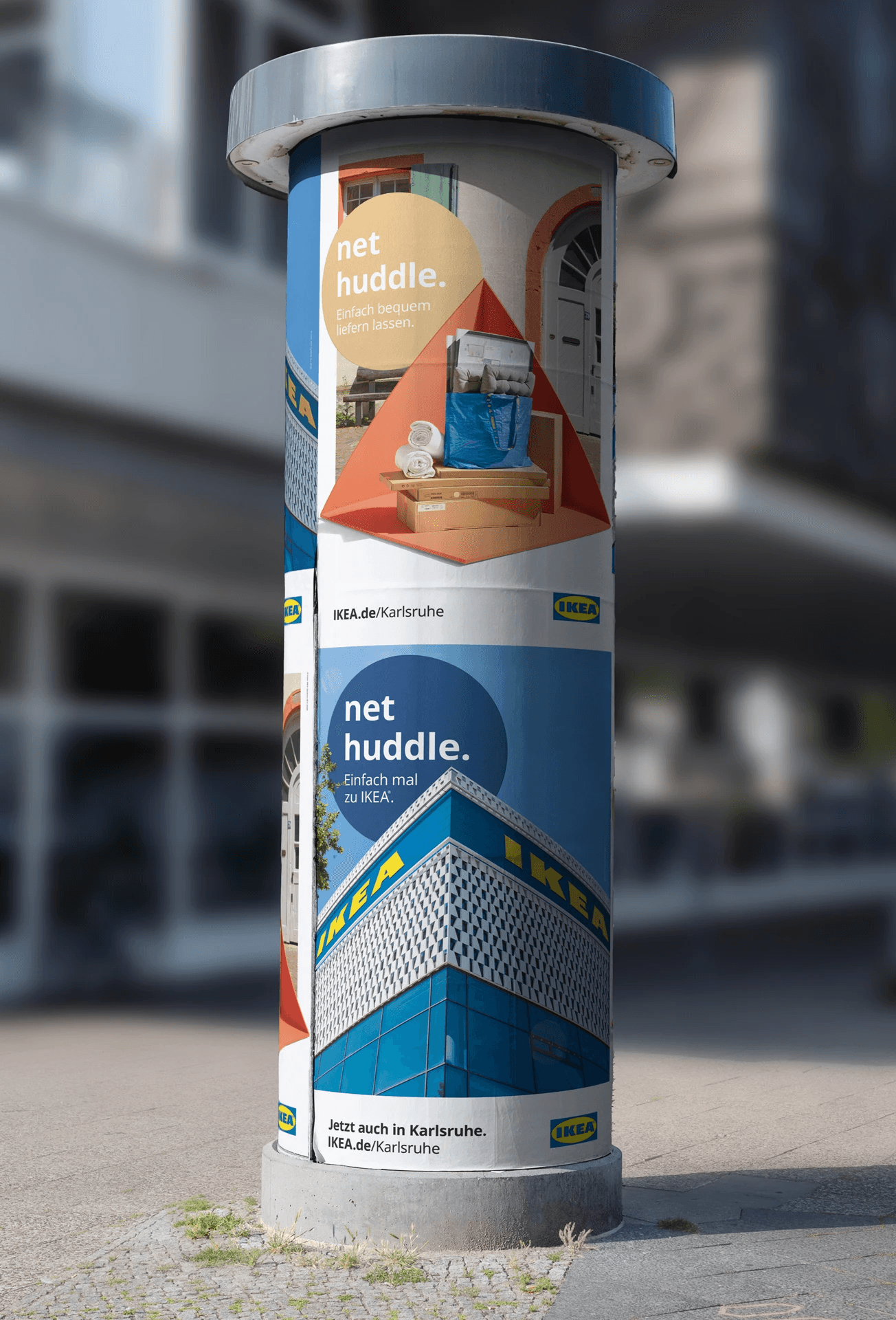 IKEA Karlsruhe net huddle campaign on a city advertising column promoting home delivery and local store opening.