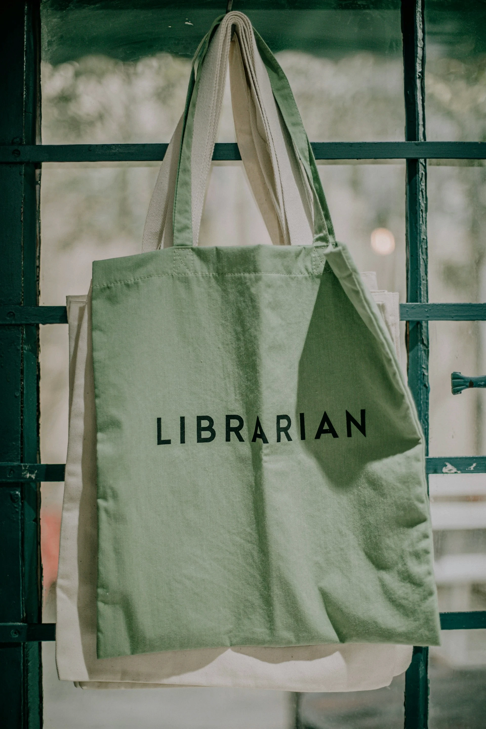 a green tote bag with black text on a window