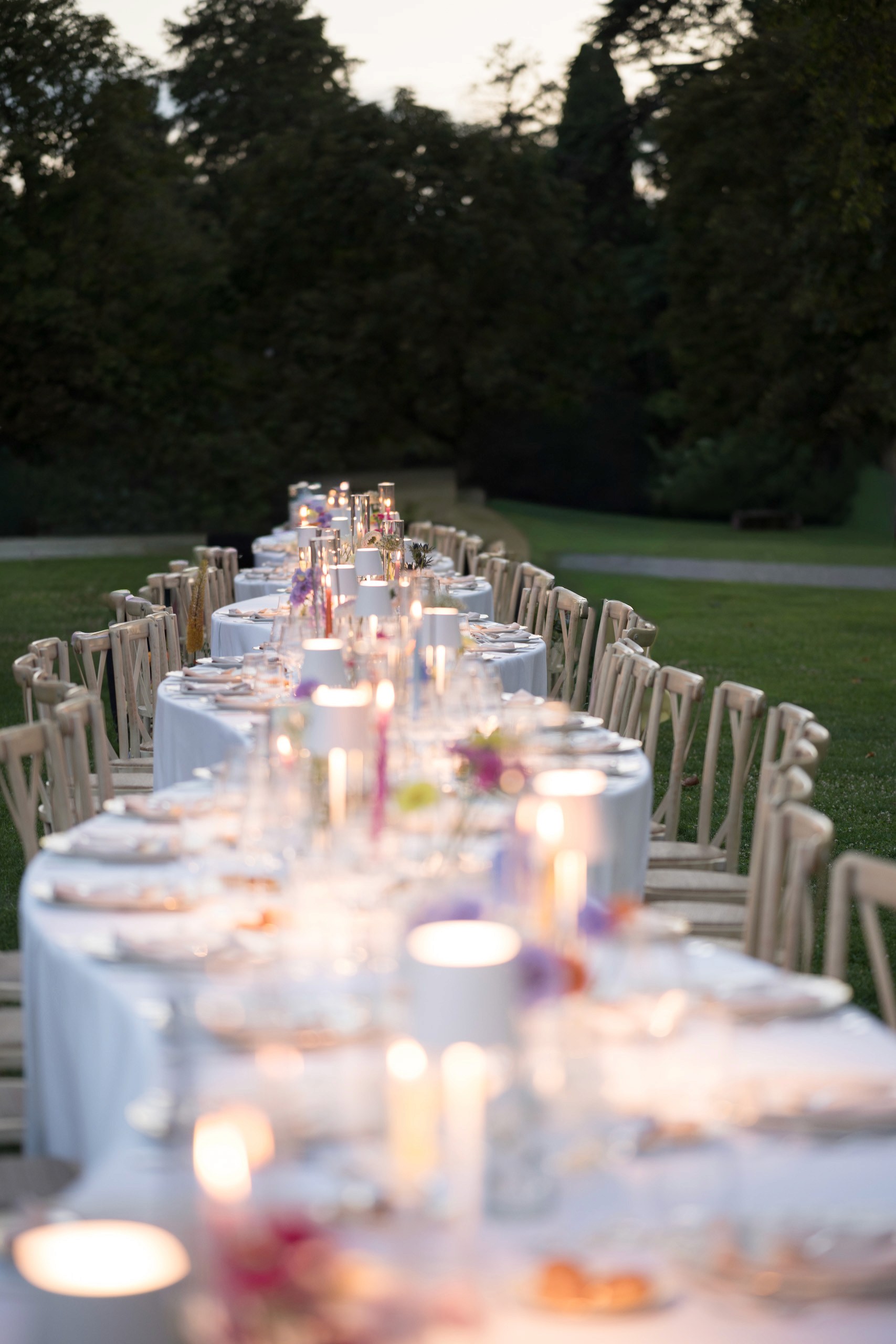 Allestimento tavola per matrimonio ed evento aziendale con luxury catering, fiori colorati, candele e mise en place elegante all’aperto