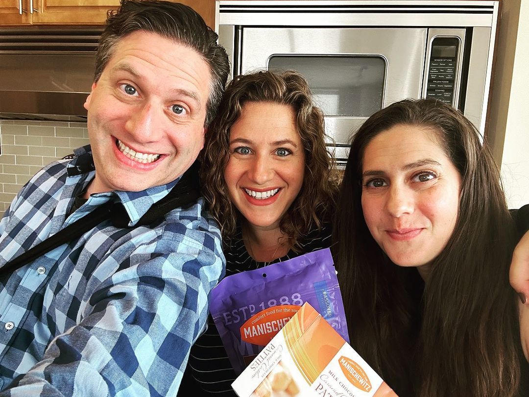 Photo of the Korman siblings smiling together in a kitchen.