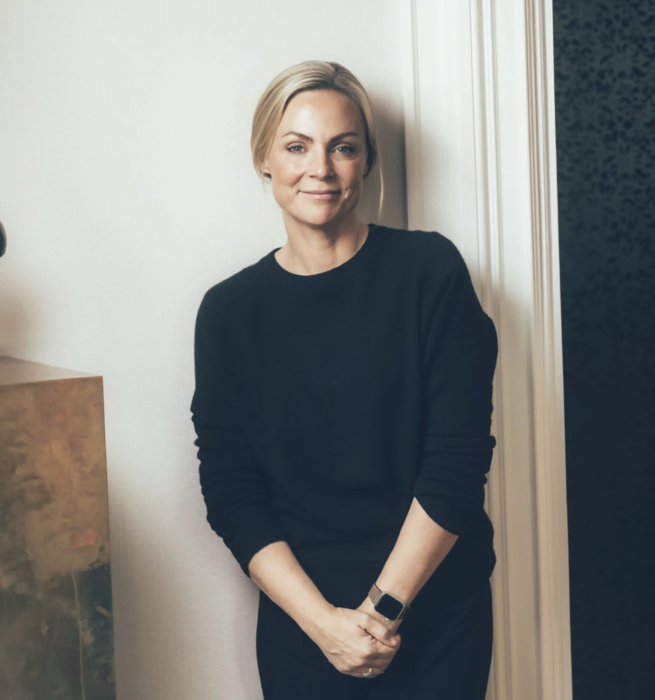 a woman standing in a kitchen wearing a sweater