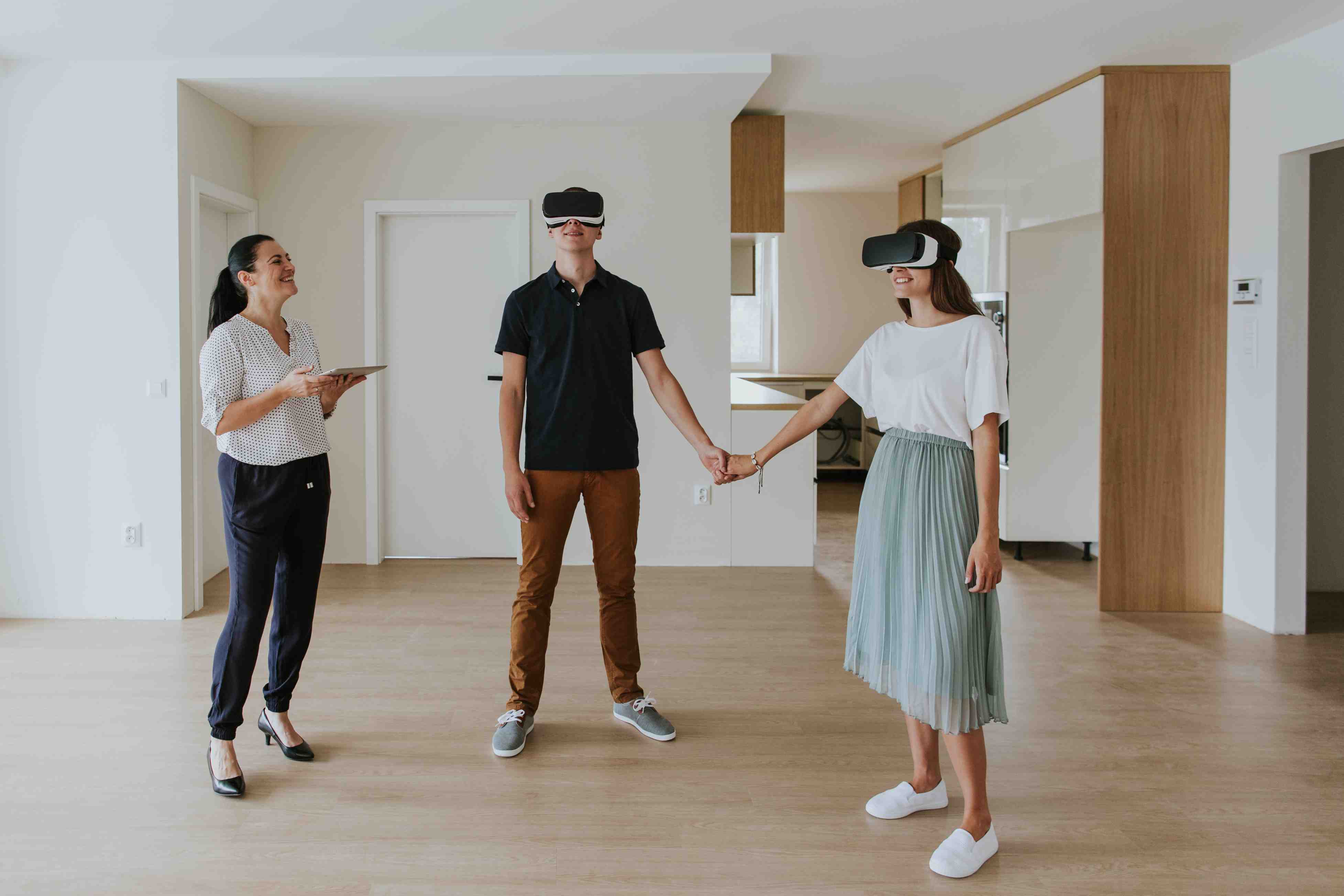 Young couple experiencing interactive walkthroughs using VR headsets during a real estate tour