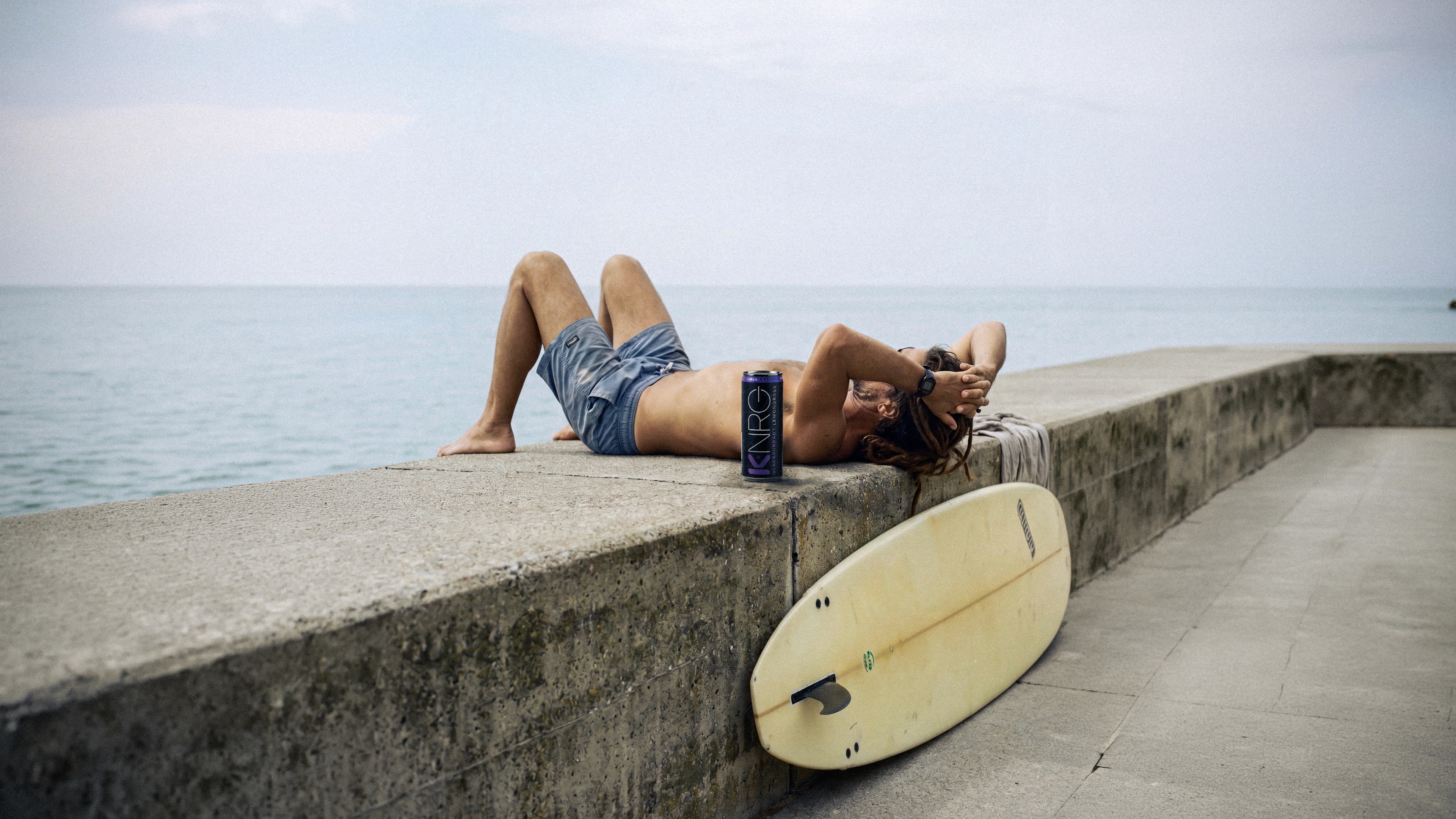 KNRG seaside scene beside a surfboard.