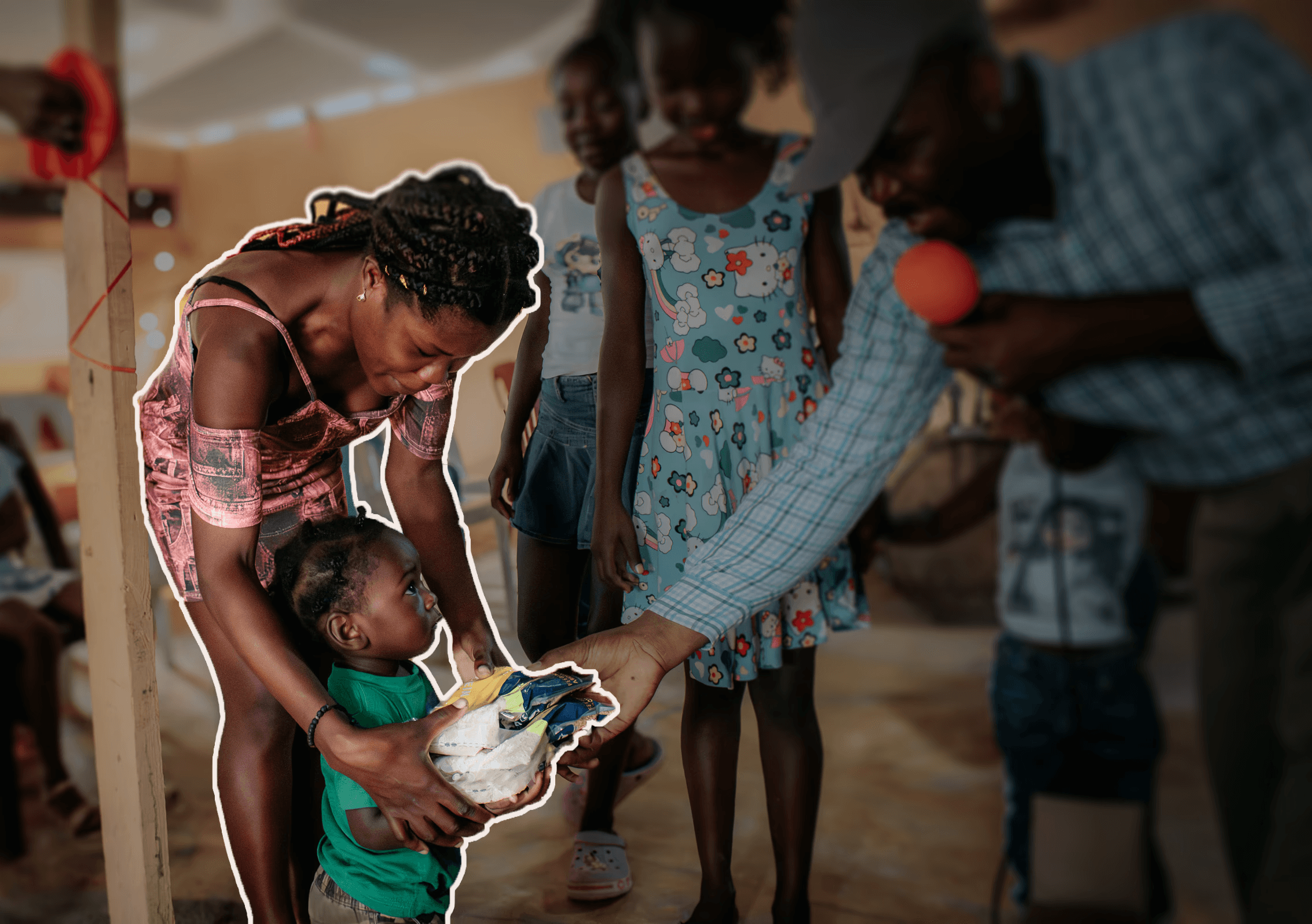 Young Haitian girl smiling while holding bags of rice distributed through a food relief program.