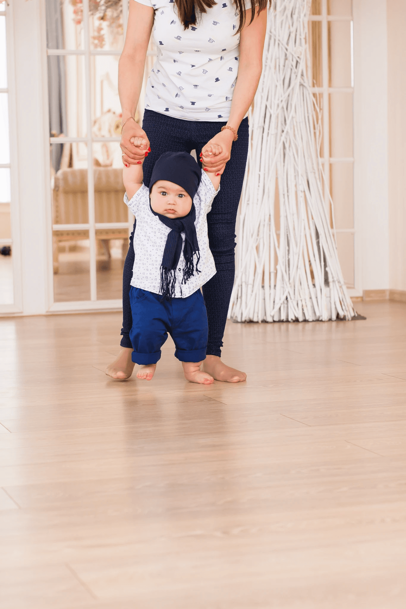 A mother helping her baby take first steps on stylish hybrid flooring, highlighting LUXO Floors’ durable, waterproof, and family-friendly surface ideal for active modern homes.