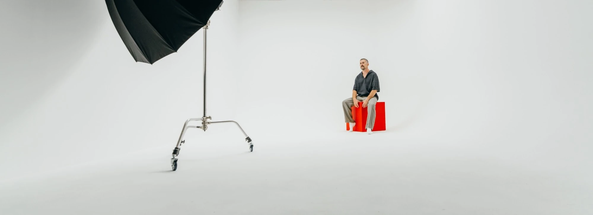 White cyclorama in Studio 60 with a lighting stand and a red cube on set