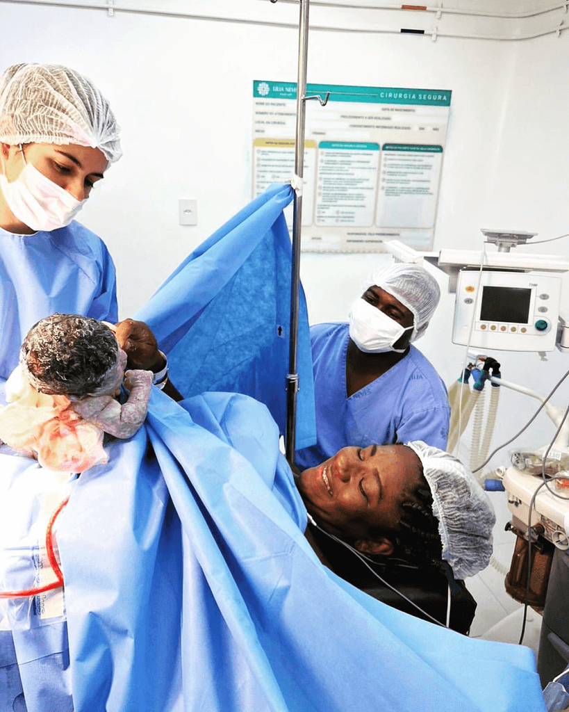 Dra. Kiara Braga, ginecologista e obstetra em Campos, RJ, realizando o parto de uma paciente em ambiente hospitalar. Com uma equipe médica preparada, a Dra. Kiara oferece cuidados durante o nascimento, garantindo um parto seguro e humanizado para mãe e bebê. Especialista em partos normais e cesáreas, ela proporciona um atendimento de excelência.