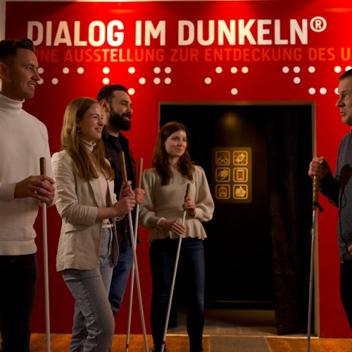 Excited visitors listen to a blind guide.