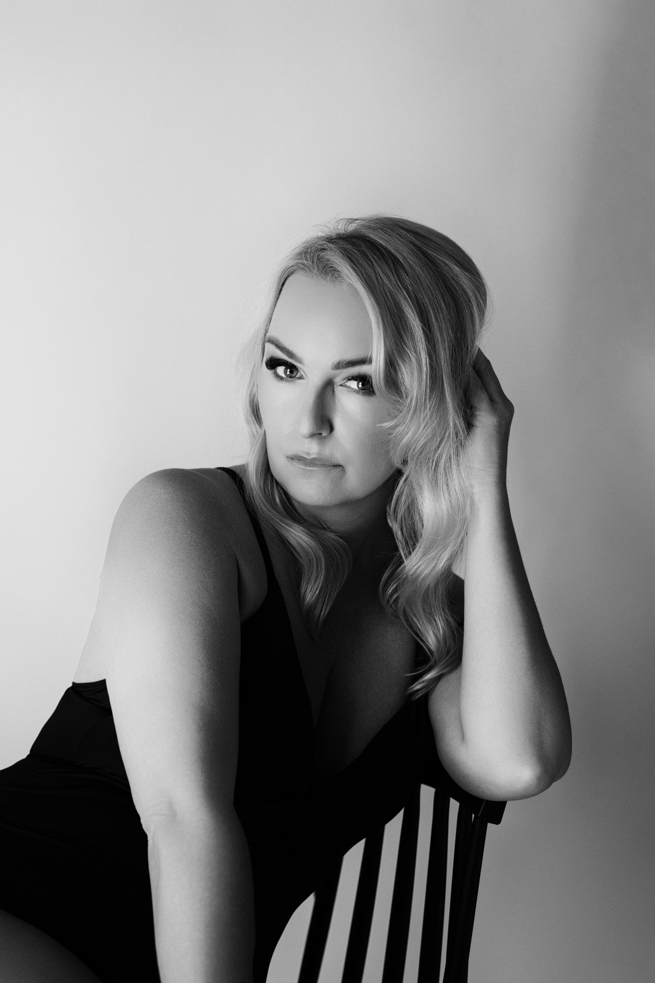 Agnieszka Czyzkowska kobiece sesje fotograficzne Warszawa kobieta oparta o krzeslo czarno-biale