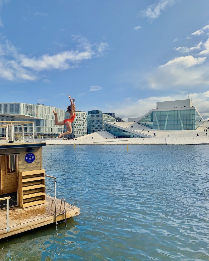 Woman jumping into sea from a floating sauna