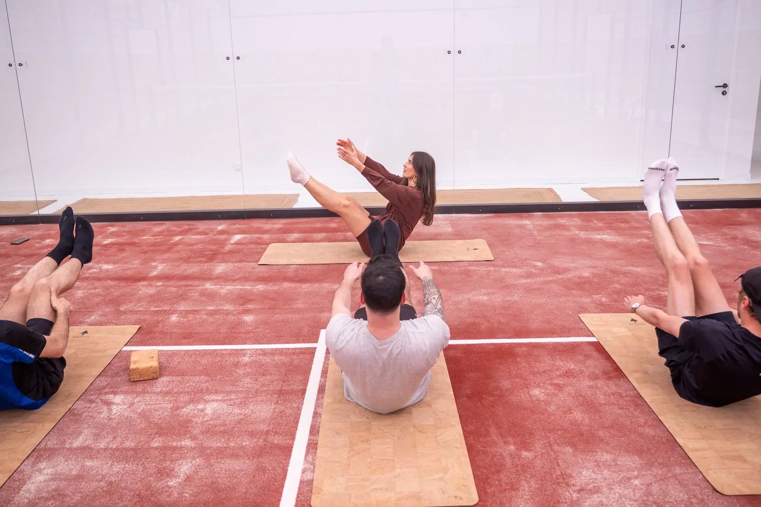 Cours de yoga avec plusieurs personnes, exercice d'équilibre en position assise