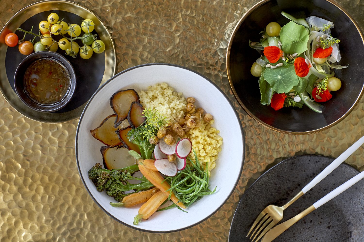 A garden-vegetable bowl and salad served on hammered brass