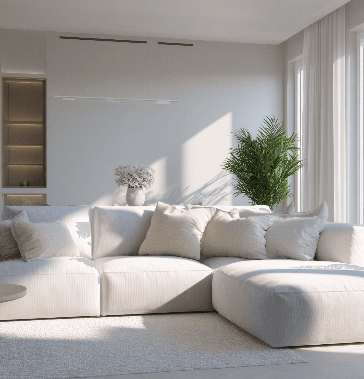 A pristine, modern living room with a white sectional sofa, representing a valuable asset in an Airbnb or short-term rental that requires protection from guest damage with robust Airbnb insurance.