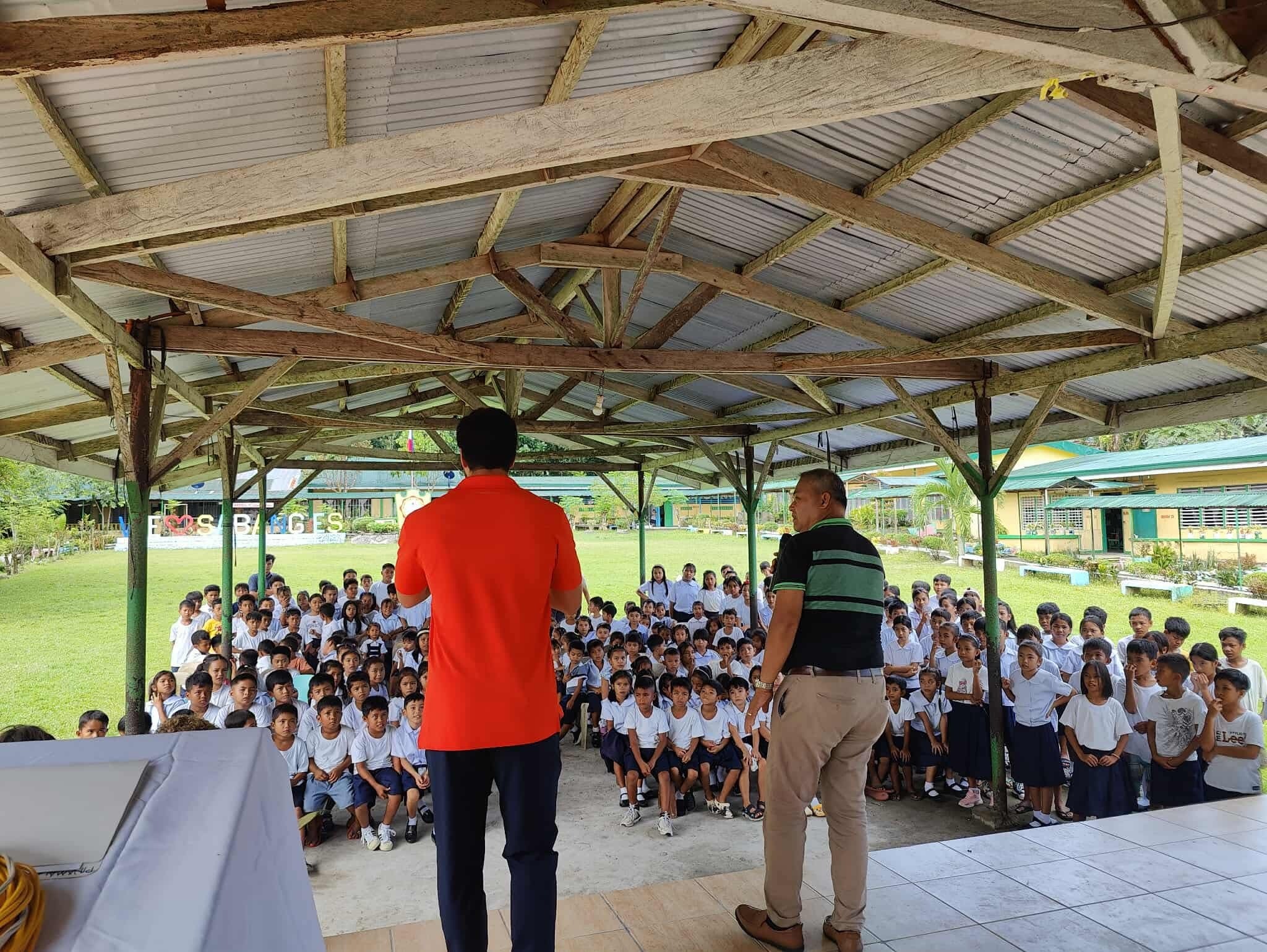 Men on stage preaching to kids