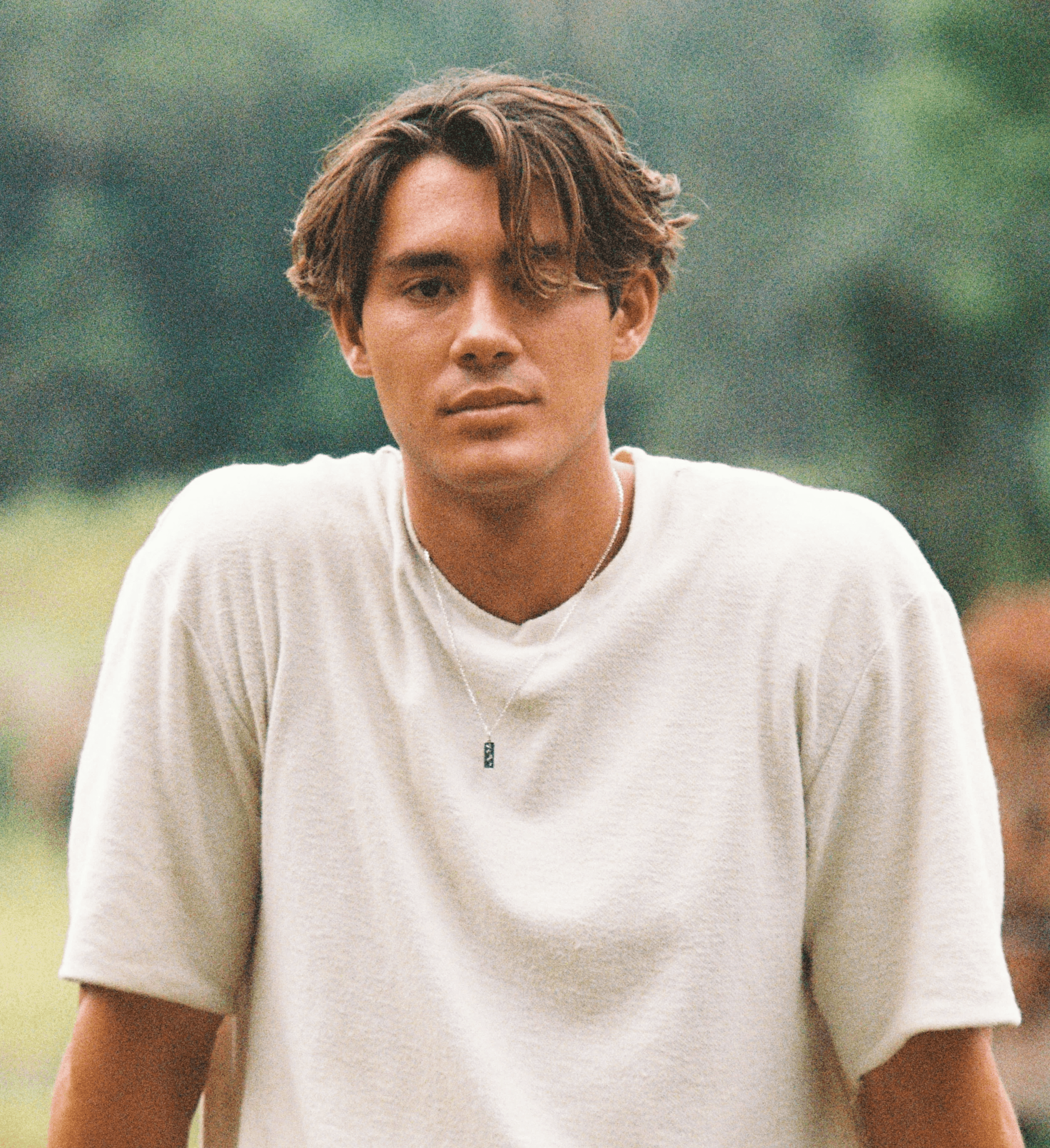 man in white crew neck t-shirt and black pants sitting on rock during daytime