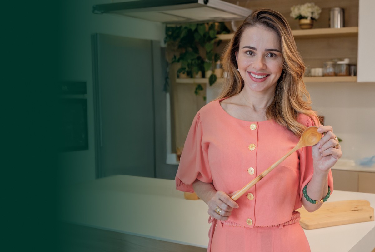 Foto da Dani sorrindo na cozinha - Hero