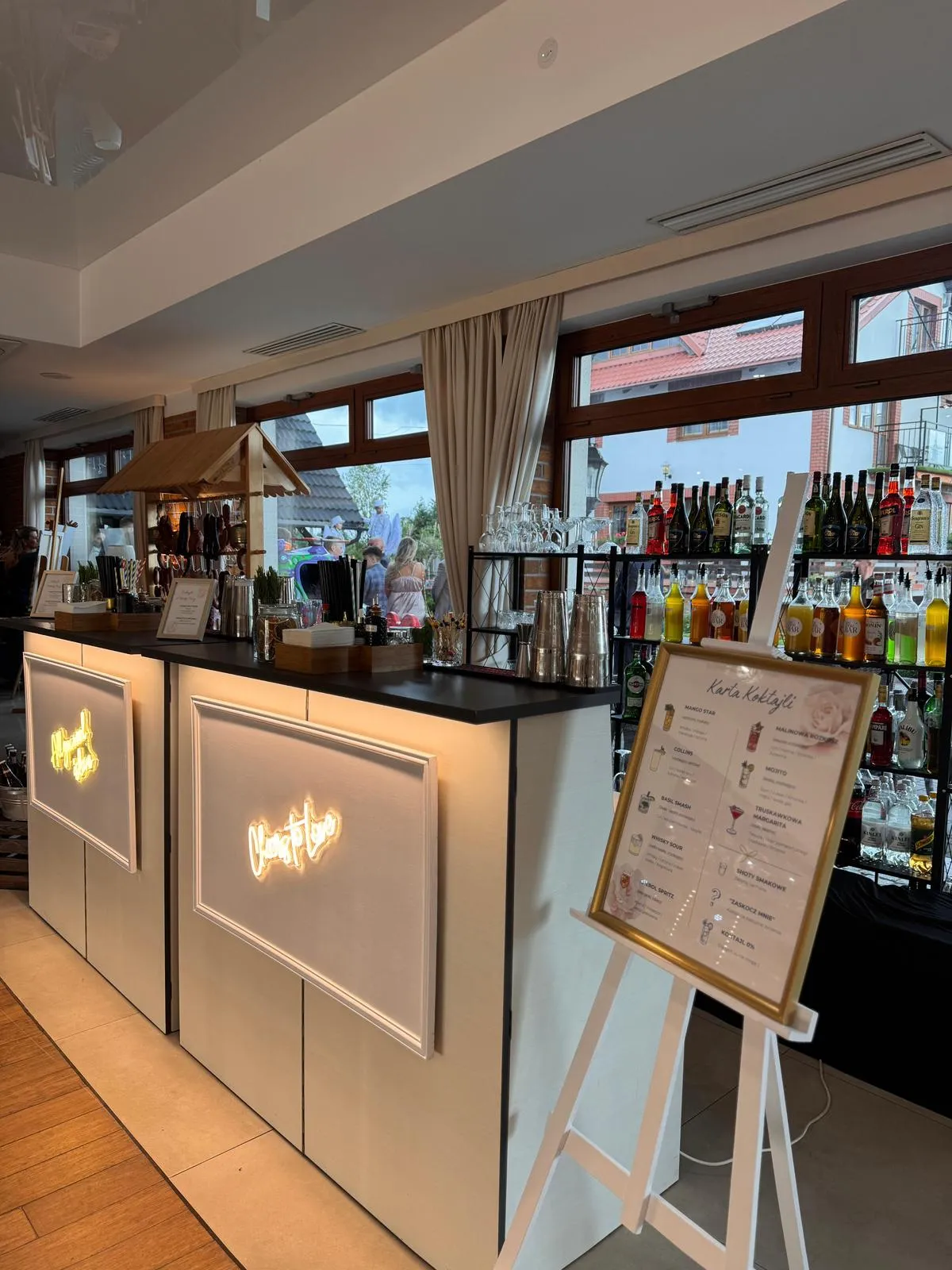 Barman na weselu pokazuje sztuczki barmańskie przed zgromadzonymi gośćmi podczas pokazu barmańskiego