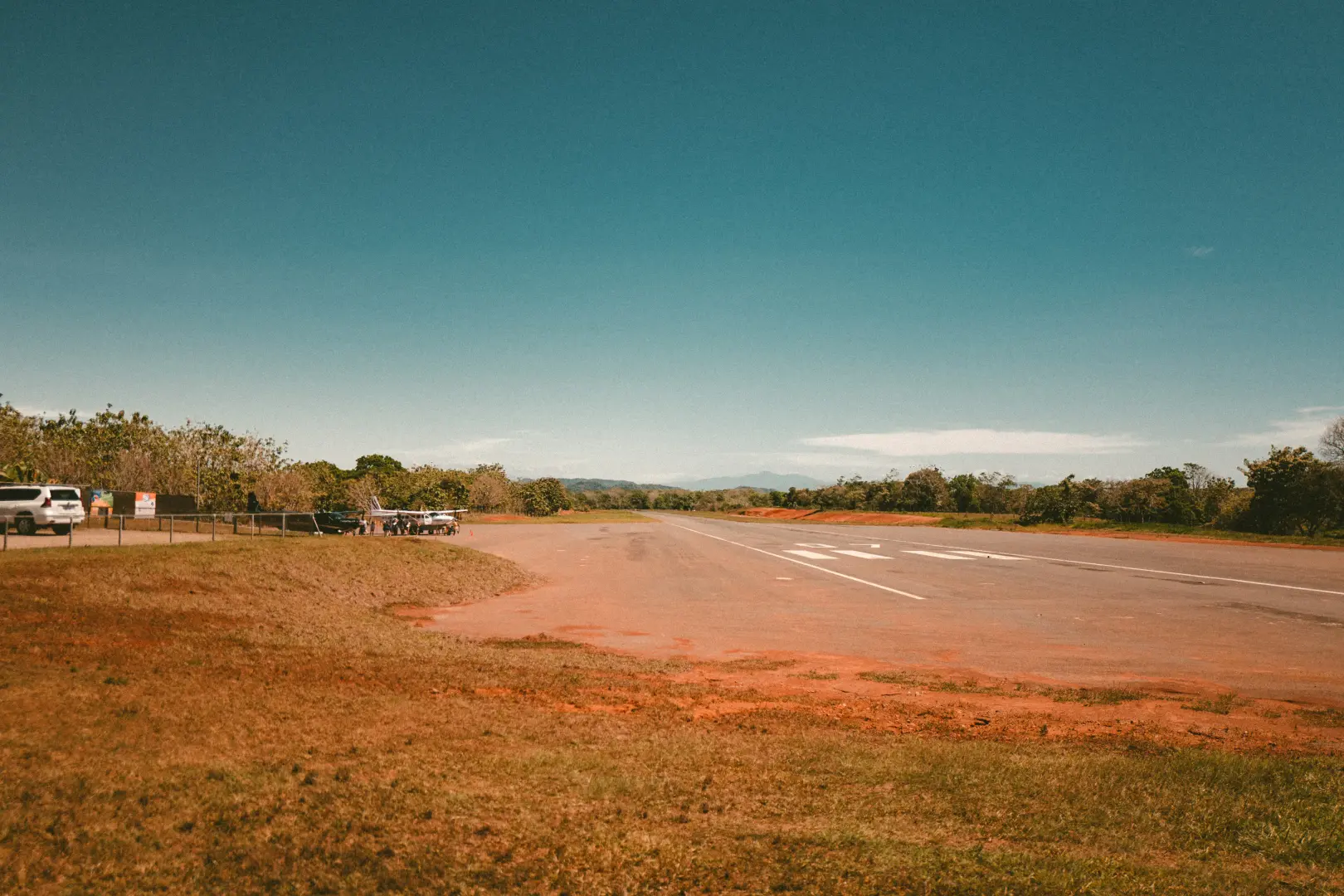Small airstrip with white vehicles and plane