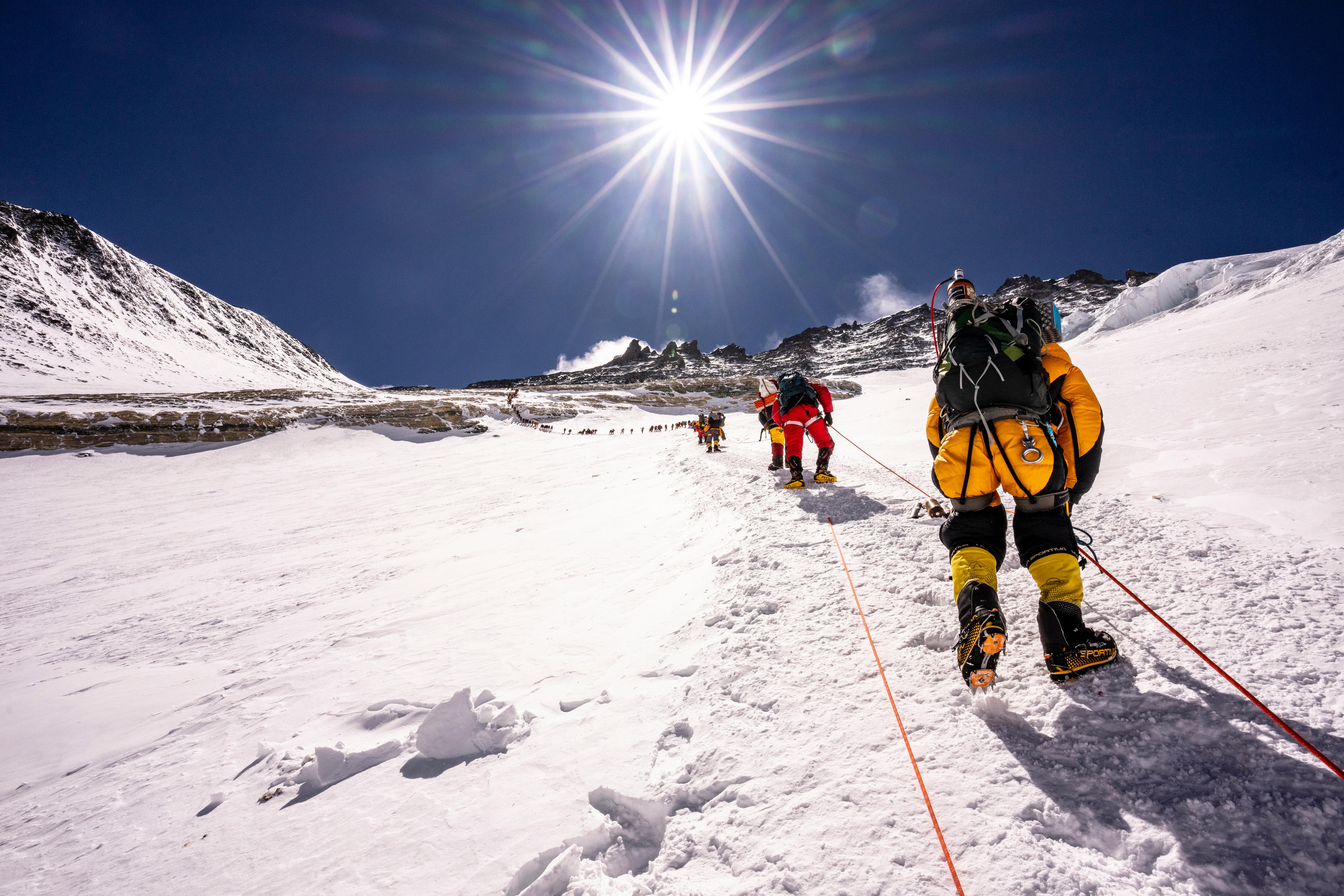 A woman capturing a photo with her camera while lying on the floor.