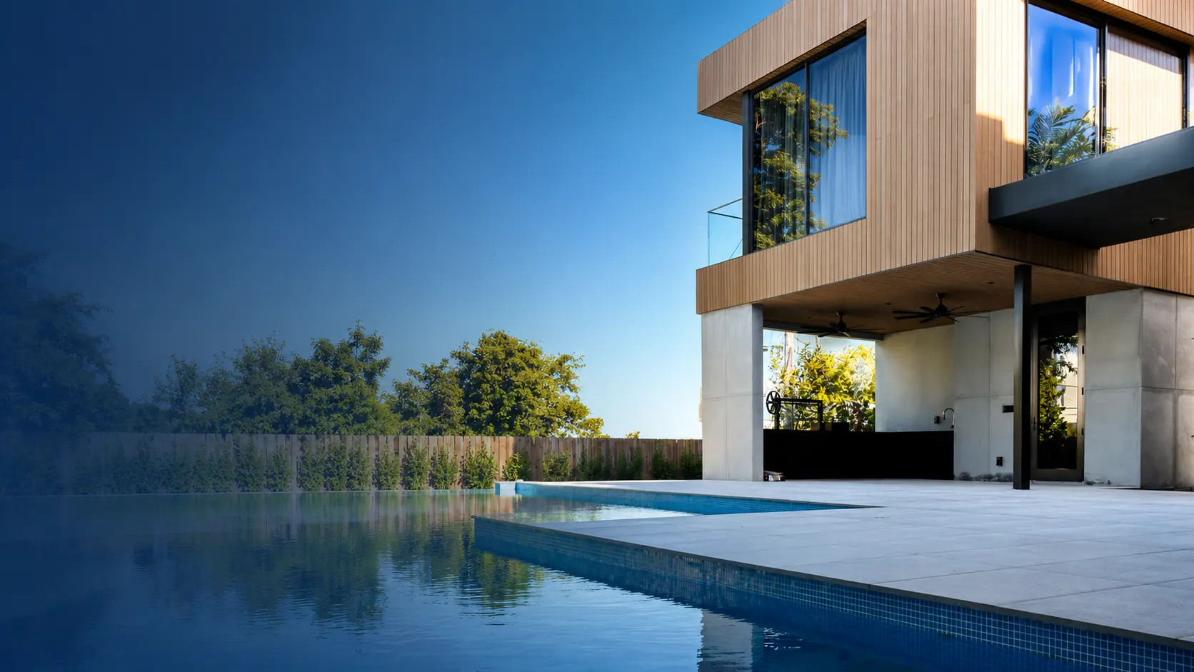Modern residential architecture with infinity pool, wood-clad upper level, and covered outdoor living area designed by Atelier International in Miami.