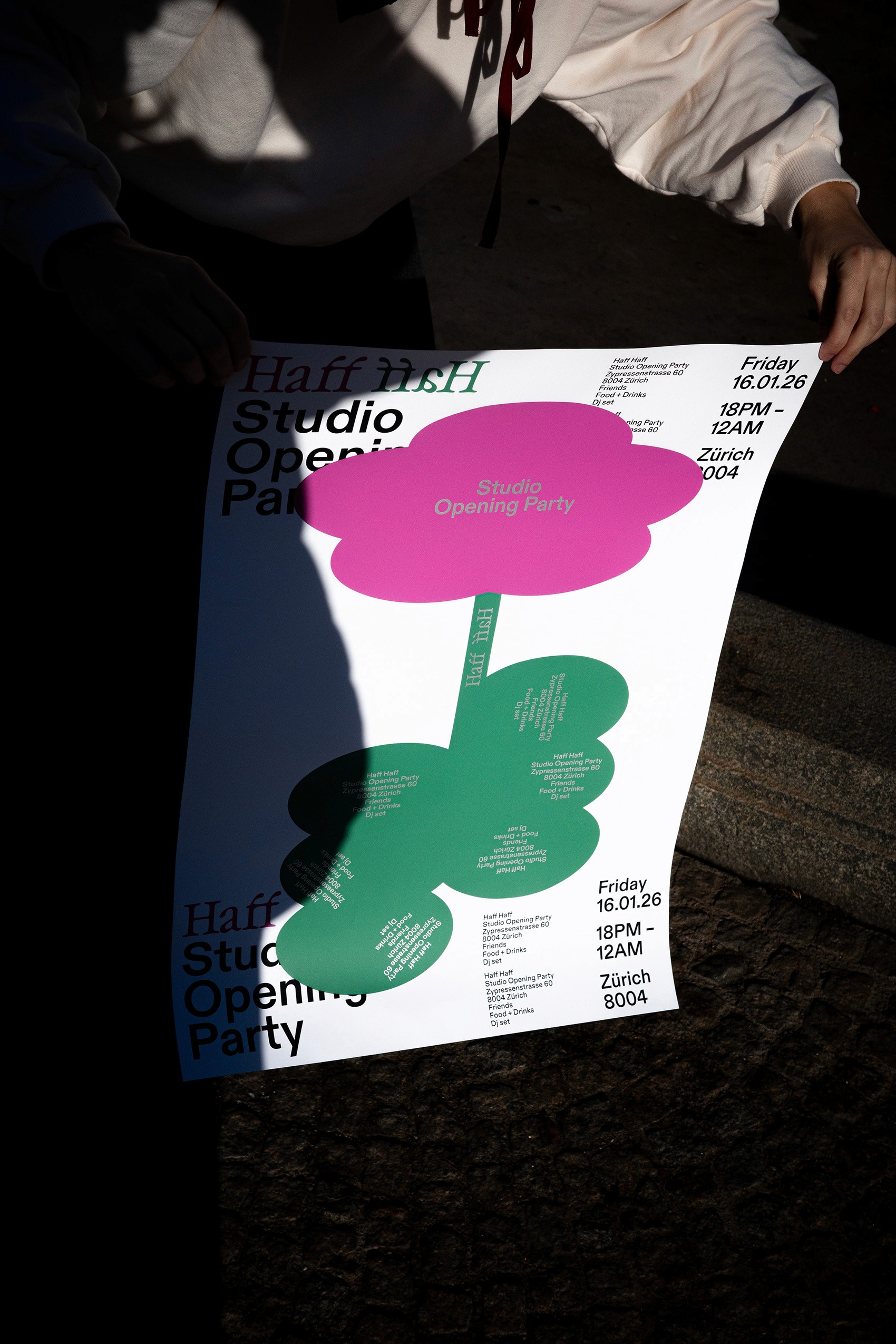 A person holding a large, white "Studio Opening Party" poster featuring a playful, stylized green and pink flower design. This visual highlights the studio's proficiency in event branding and bold graphic design, marking the official launch of their new creative space in Zurich.