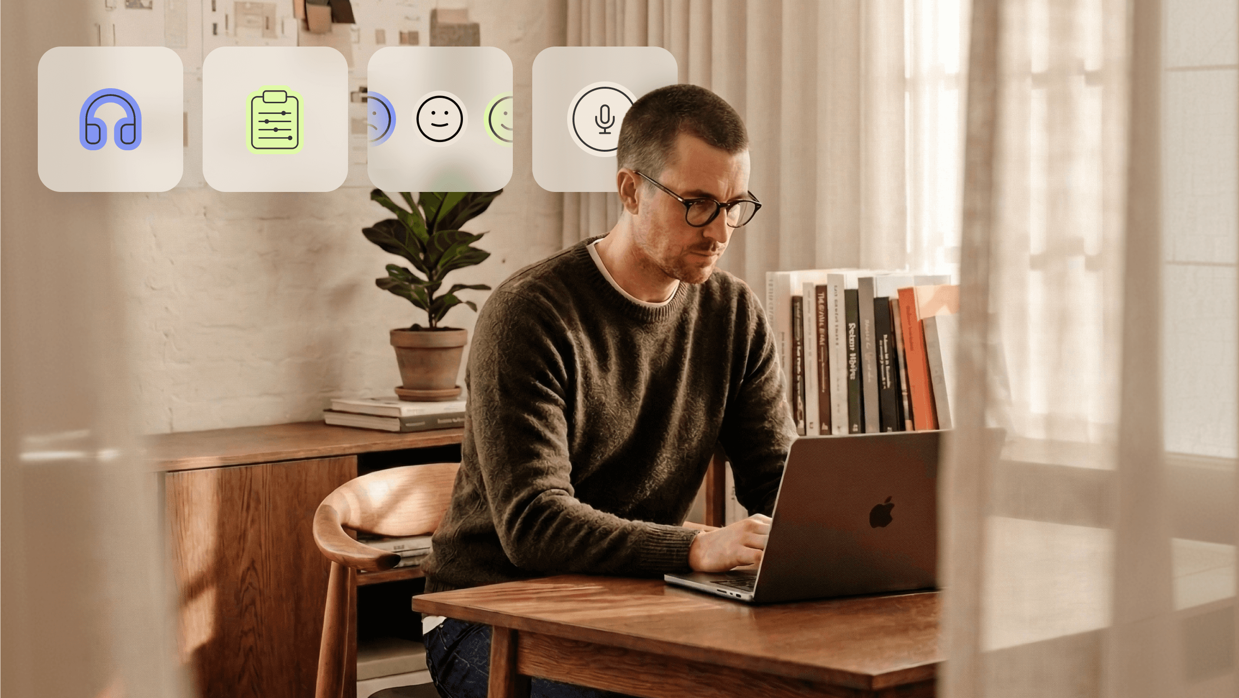 A man with glasses and a green sweater is looking and typing on his laptop at a wooden table in a well-lit room. Floating in the air, there are four large buttons with different symbols. The first button shows headphones, the second one has a document with some details, the third has a face with a range of expressions from sad to happy, and the fourth one features a microphone. The background shows a plant, some books and light curtains.