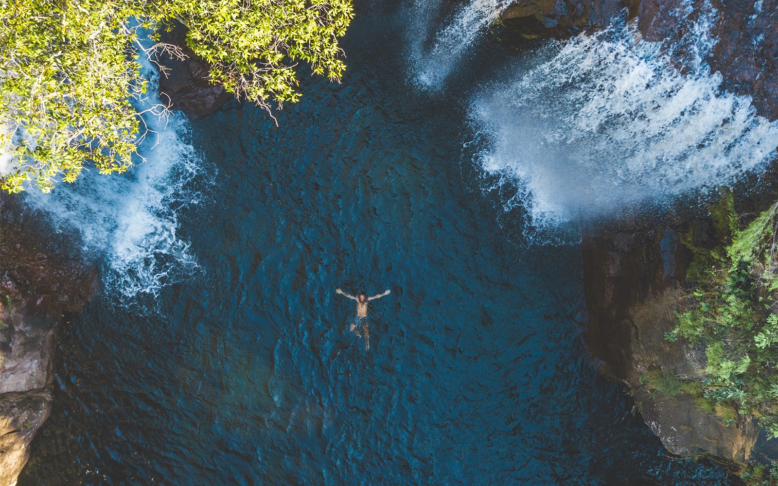 Swimming beneath waterfalls at Litchfield National Park, Australia.