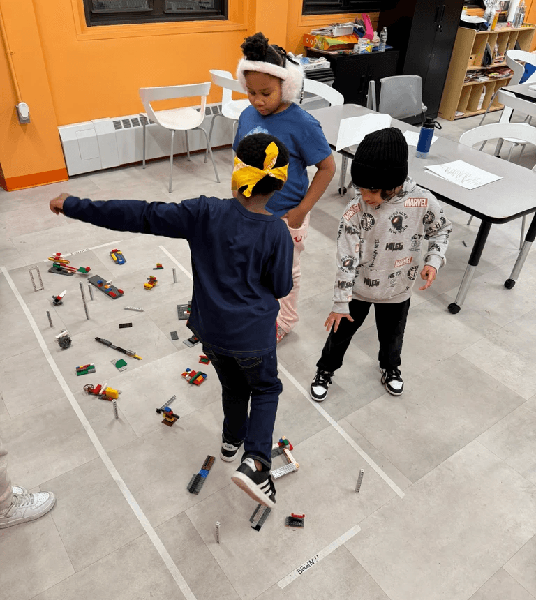Participants guide their blindfolded peer through an obstacle course.