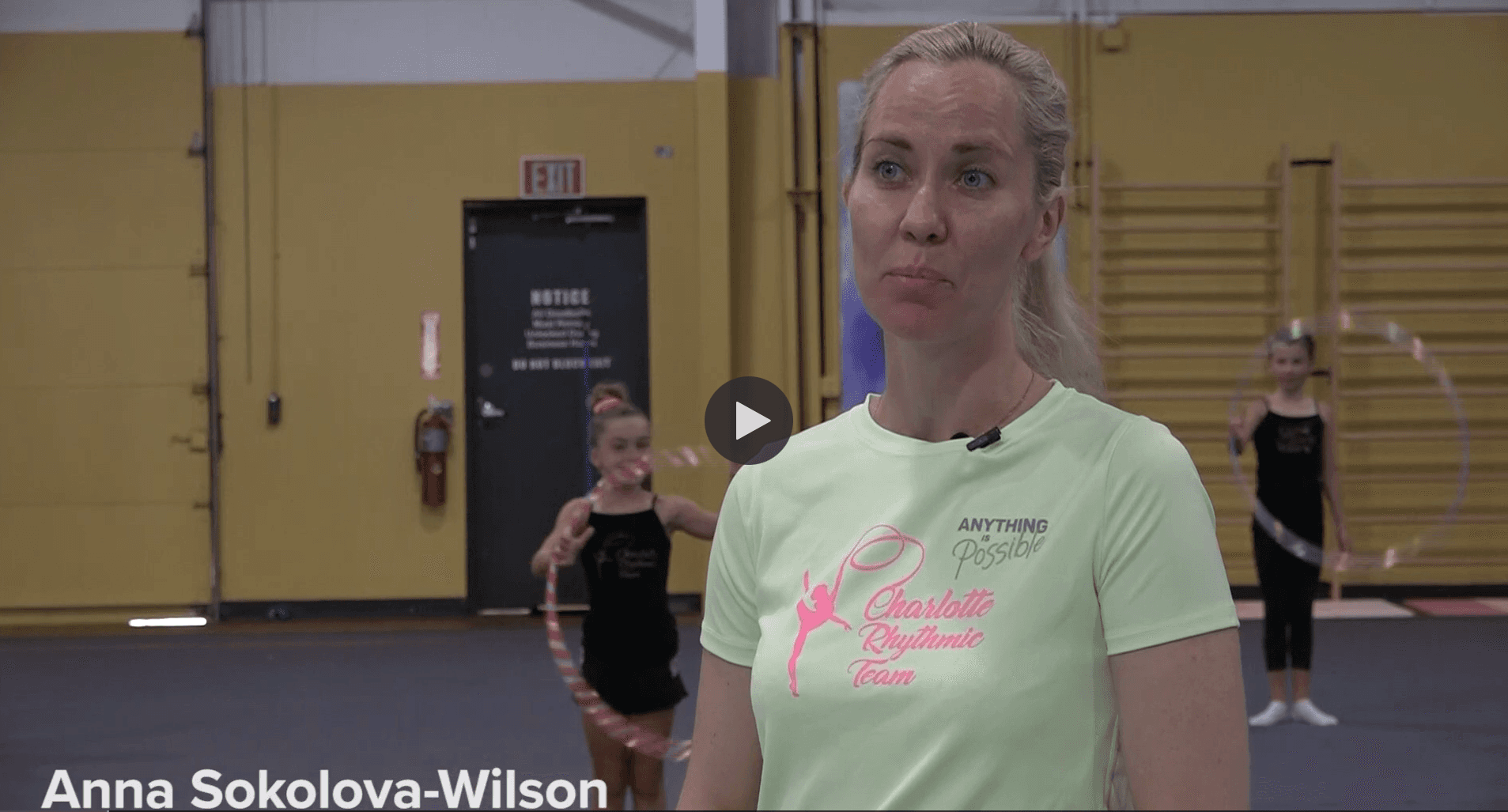 Thumbnail for video of our gymnastics program being on local Charlotte tv showing our head coach Anna Wilson with a few gymnasts training with hoops behind her