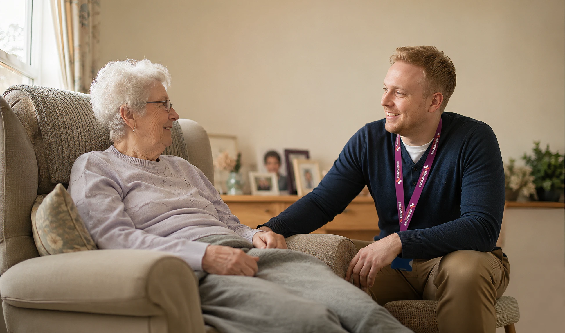 Care support worker providing companionship to an elderly woman receiving palliative care at home.